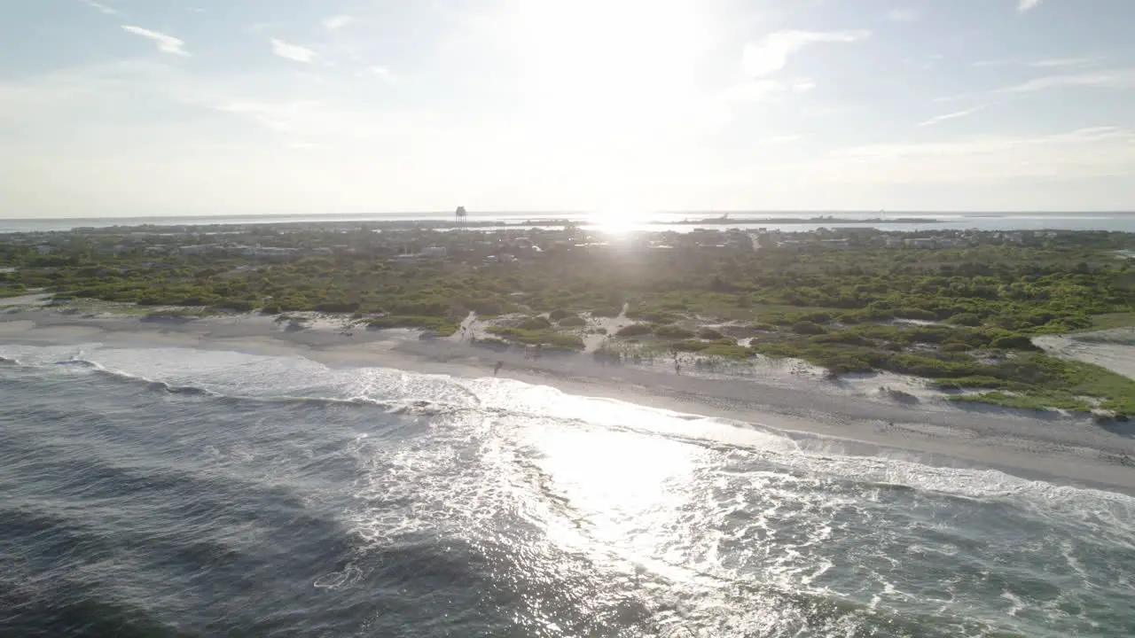 Light House aerial drone move to ocean surf crashing on beach beautiful fly down the coast