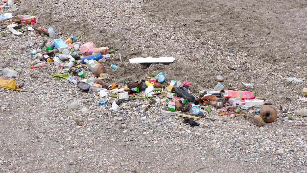 Environmental disaster with piles of plastic waste and rubbish washed ashore onto beach at high tide in tropical island destination in East Timor Southeast Asia