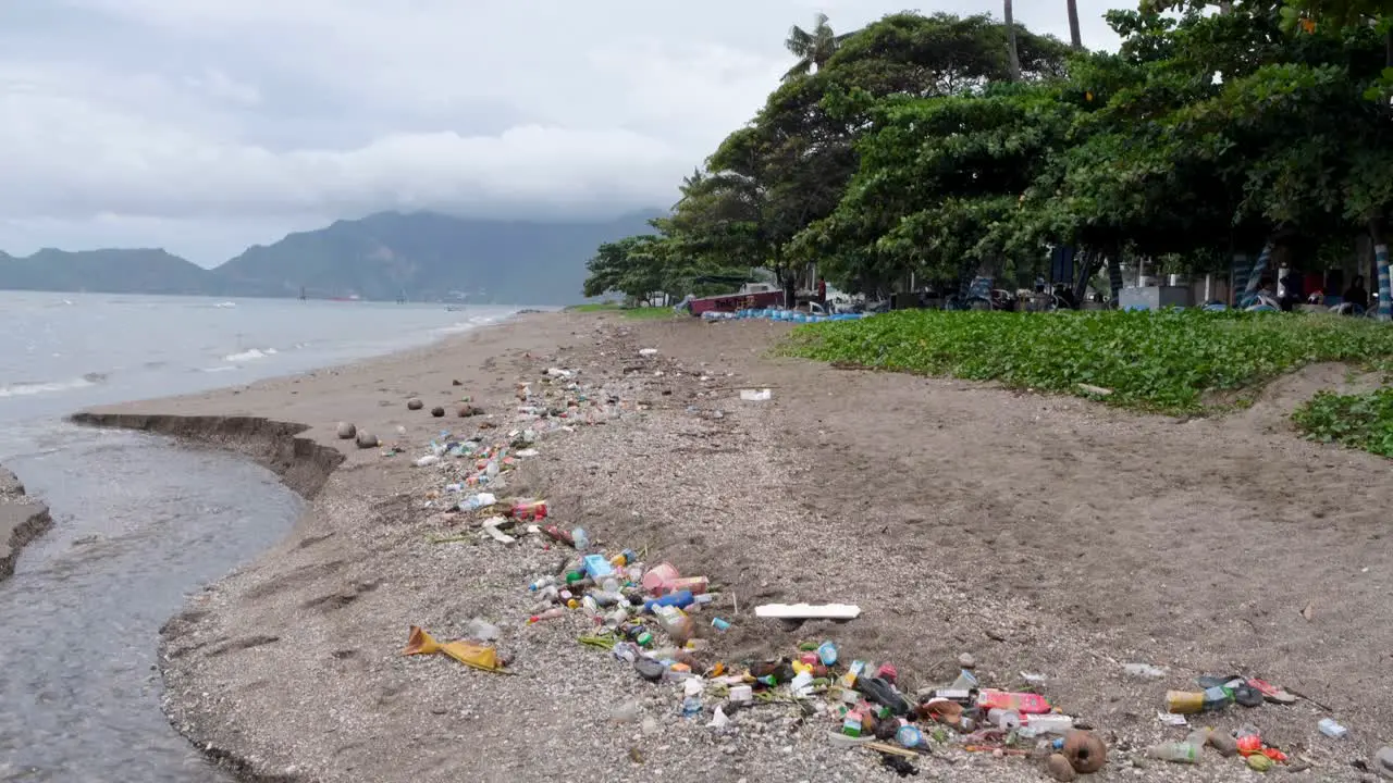 Heaps of plastic waste and rubbish polluting beach washed up from ocean on tropical island of East Timor in Southeast Asia