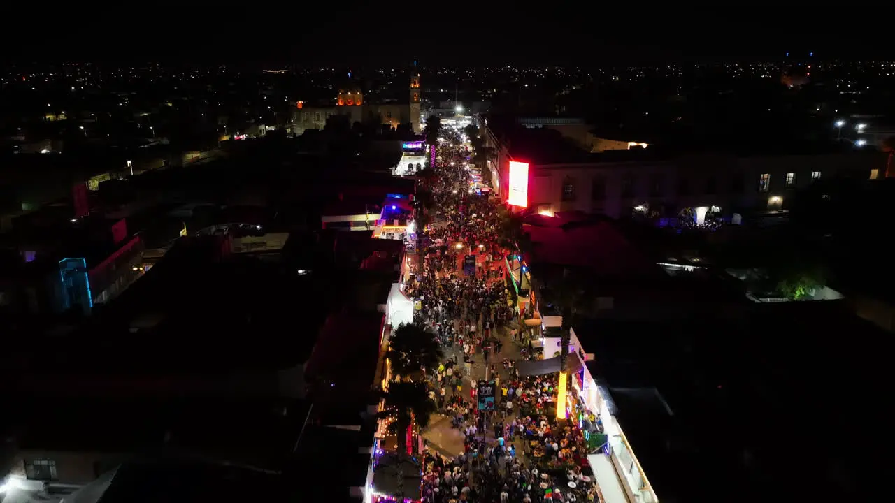 Flying over people at the Feria San Marcos Aguascalientes event night in Mexico Aerial view