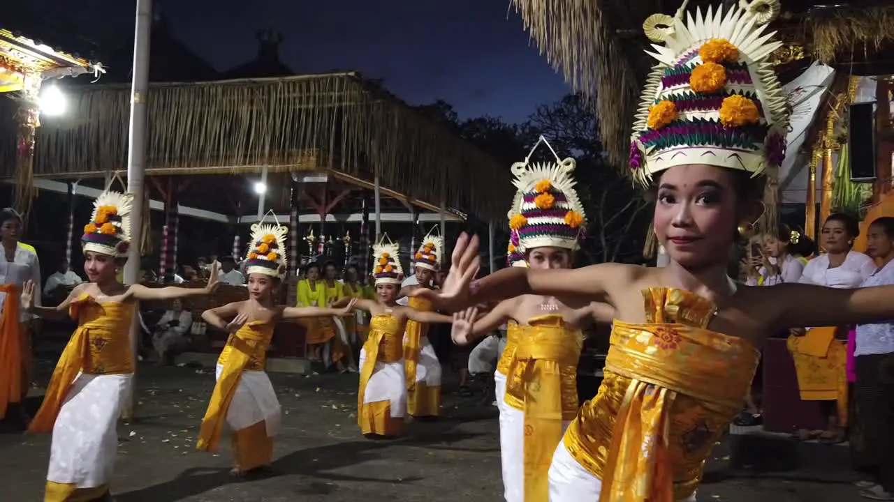 Girls perform Rejang Dewa Dance part of Balinese Hinduism Temple Ceremony wearing Colorful Outfits with Fruits Flowers and Crowns