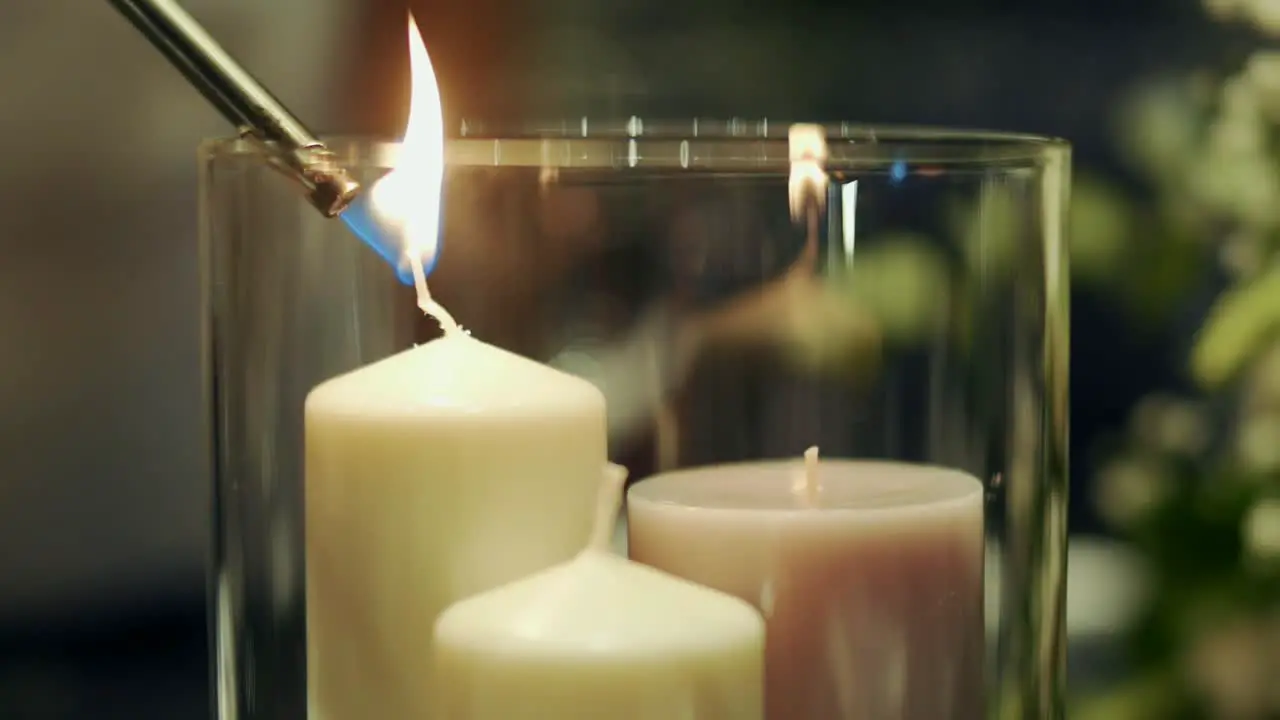 Candles inside a glass candle holder being lit