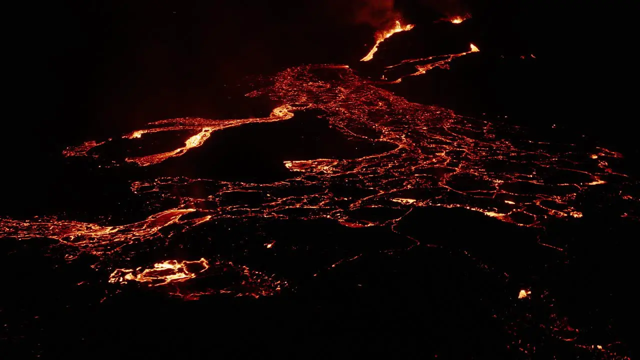 Iceland lava field with molten magma flowing as rivers on dark surface at night