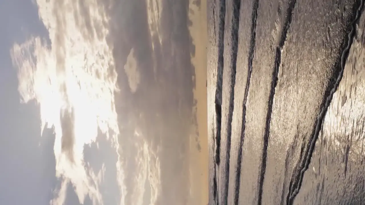 Vertical drone shot of waves washing ashore