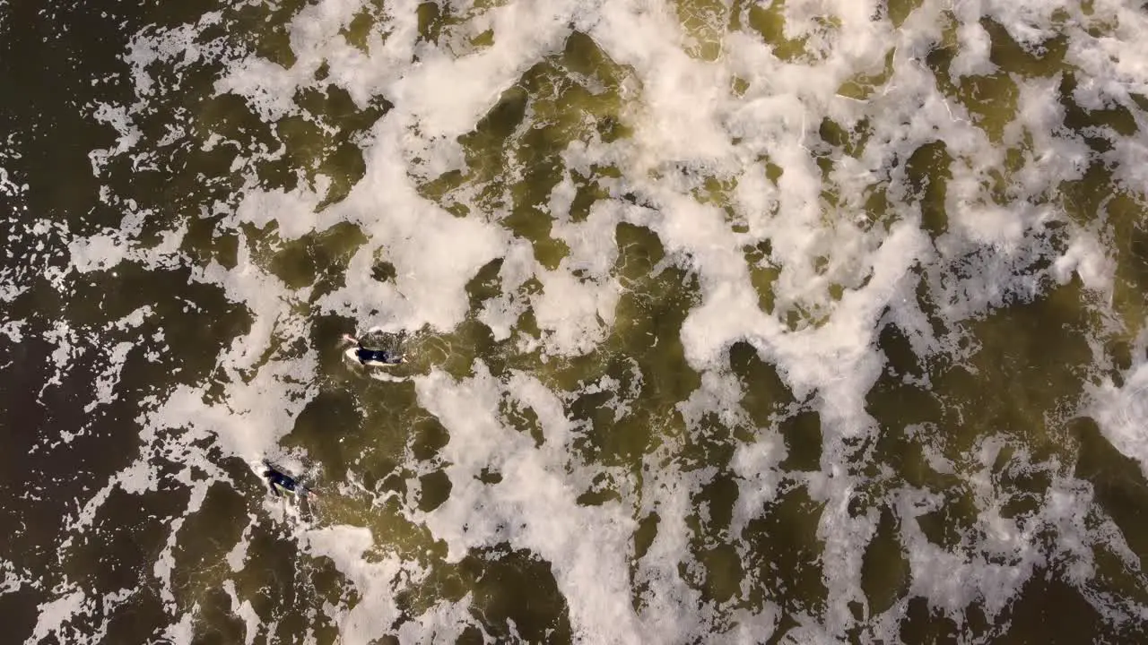 Drone sky shot of two surfers paddle in brown storm water ocean waves Birdie Beach Munmorah State Conservation Area Lakes Beach Central Coast NSW Australia 3840x2160 4K