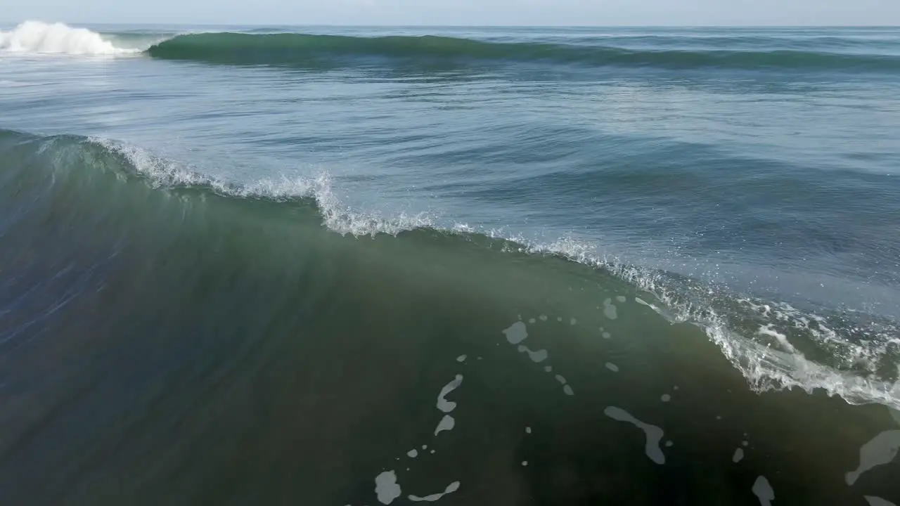 AERIAL Camera follows deep blue crashing wave