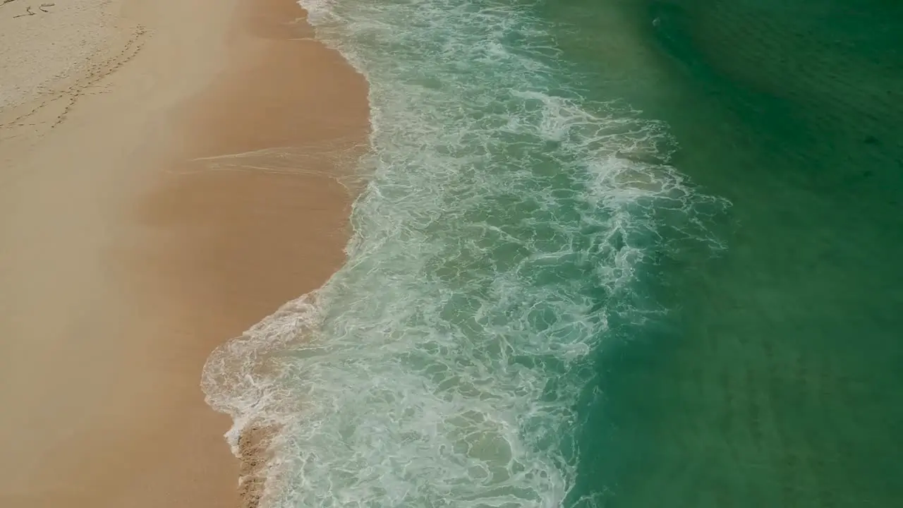 Waves breaking onto yellow sand beach