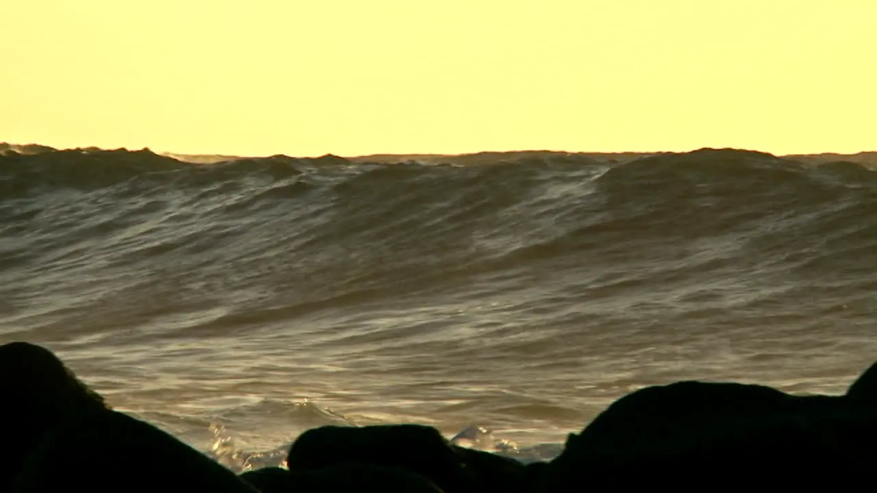 Large waves as they crest and break in slow motion at sunset