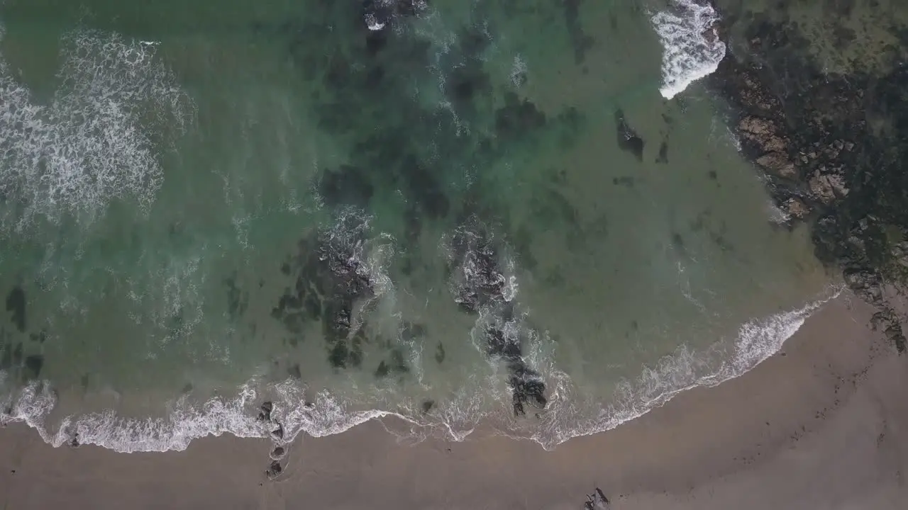 Small waves hitting the rocks on the beach