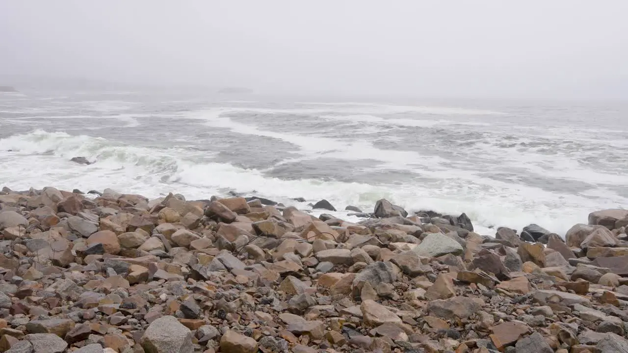 Waves crushing on rocks on a foggy day