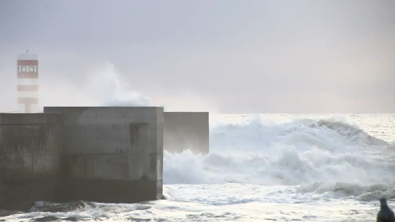 Waves crushing lighthouse in Porto in a cold cloudy and windy evening