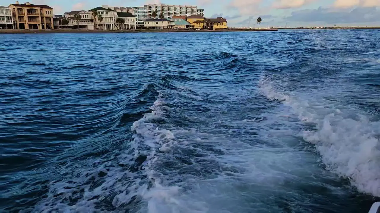 Waves from a boat in the bay to reveal coastline in Texas