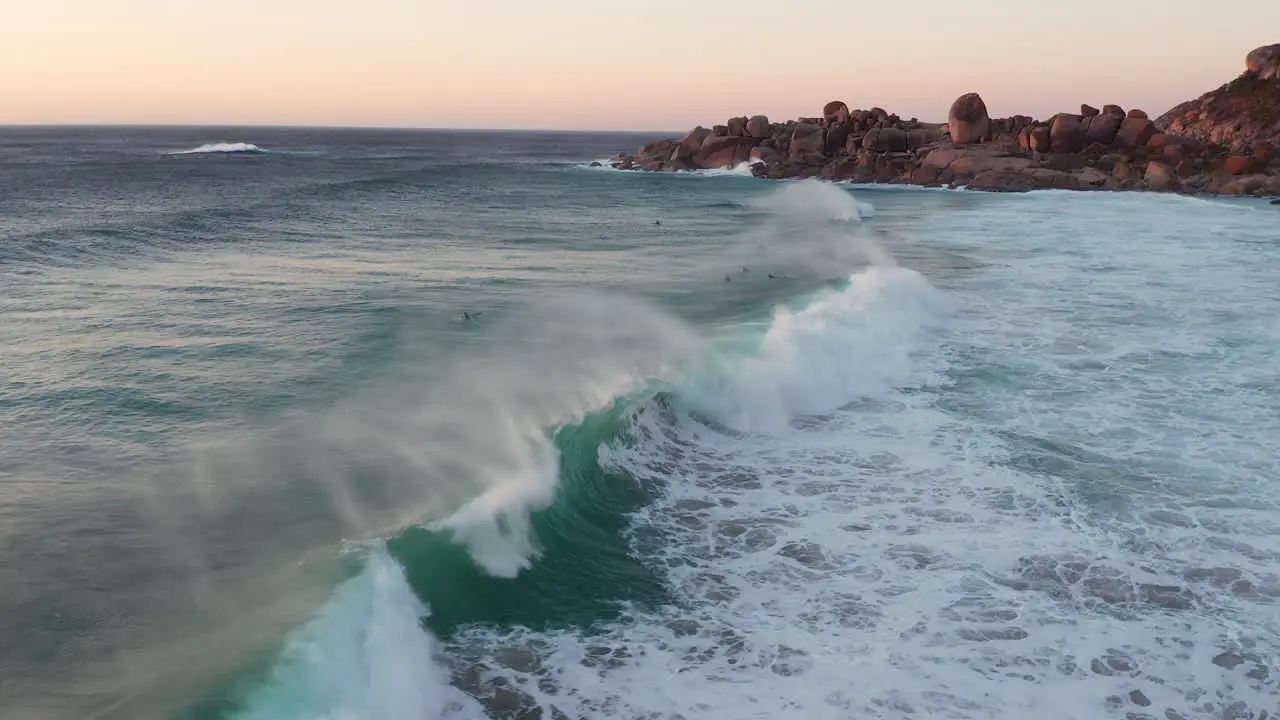 Waves Crashing and People Swiming On The Coast Nearby Llandudno in Cape Town South Africa aerial shot