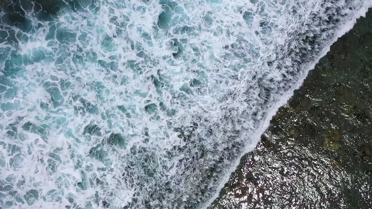 Ascending aerial view over some waves in top of the corareefs under in Reunion Island