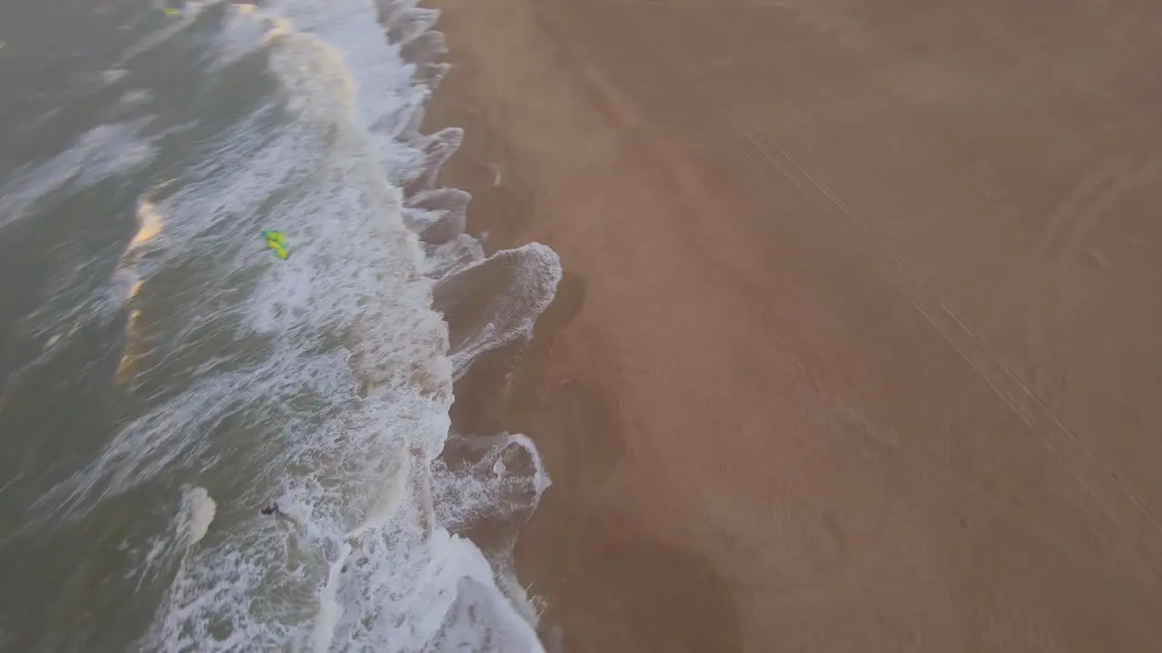 Fast orbiting drone shot around the kite of a kitesurfer during sunset