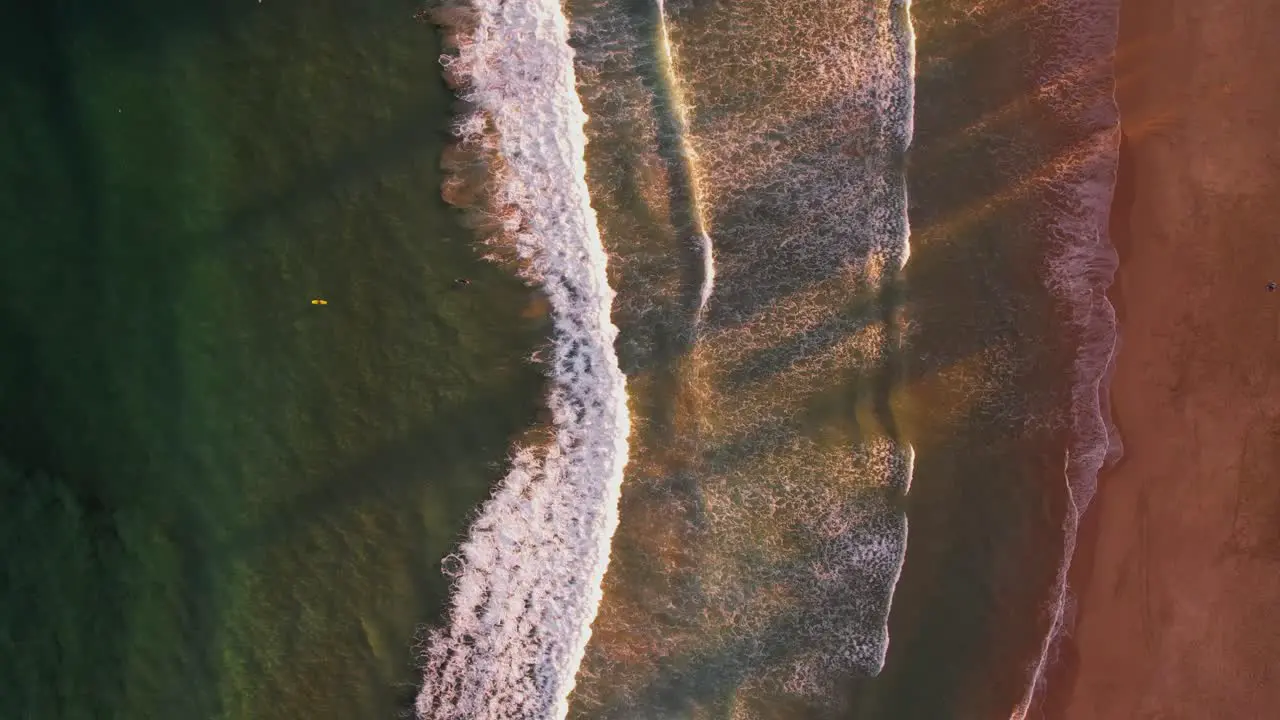 Birds Eye POV waves breaking at sandy beach