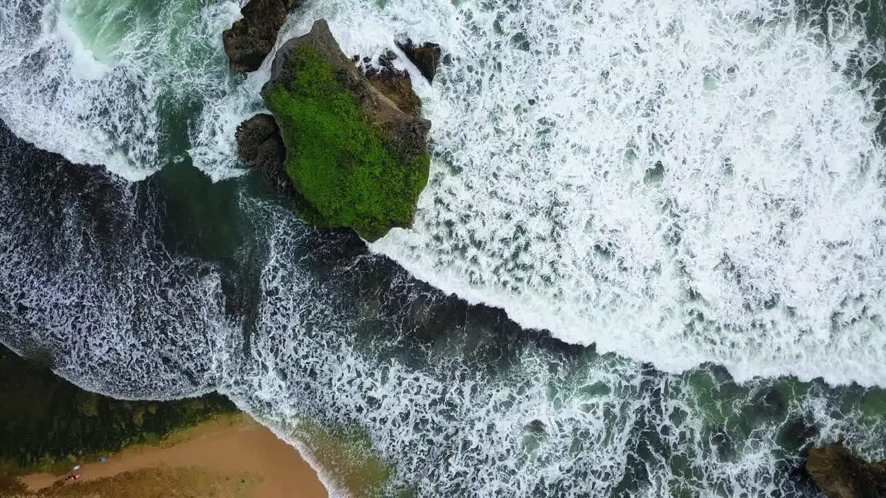 Powerful waves reaching shore and rocky island during stormy day in Indonesia