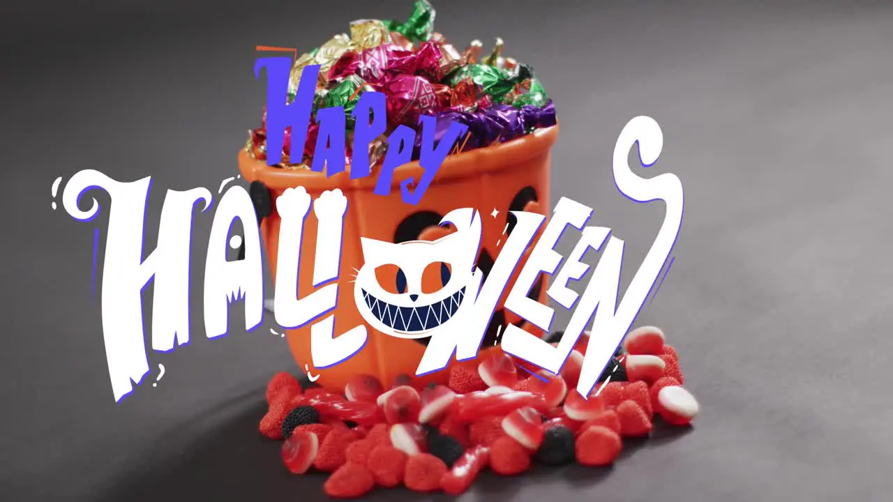 Animation of happy halloween text over orange pumpkin bucket with sweets