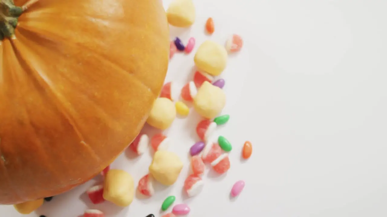 Close up view of pumpkin and candies against grey background