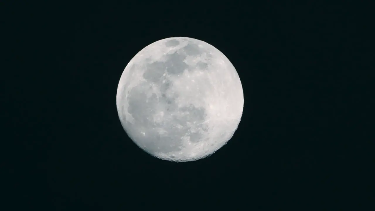 A shot of a full moon slowly rising in the sky in Tokyo Japan