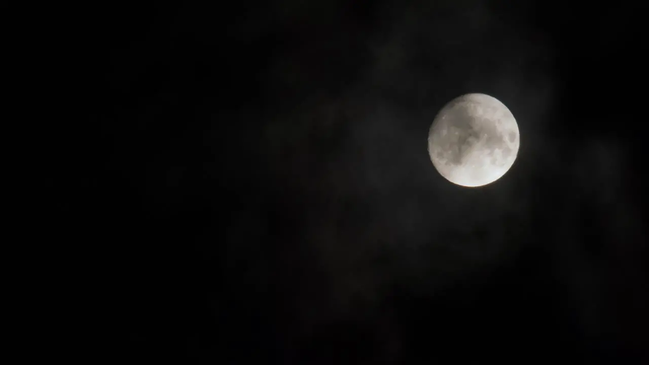 Moon shrouded by clouds against a dark sky evoking mystery and the beauty of the cosmos