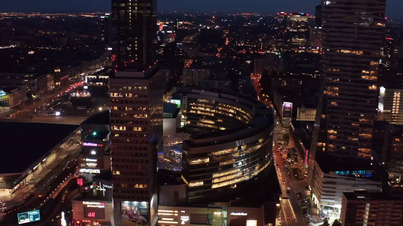 Aerial night footage of downtown Revealing Zlote Tarasy modern shopping and entertainment complex Warsaw Poland