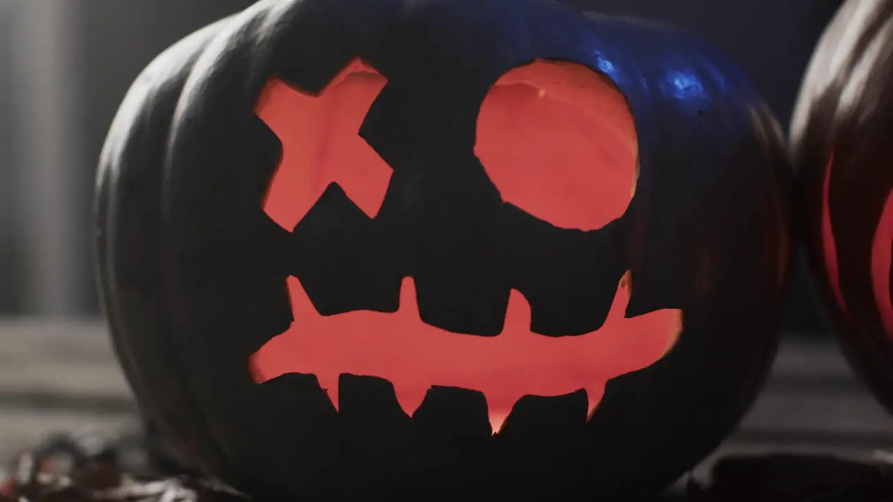 Video of halloween carved pumpkin and smoke with copy space on dark background