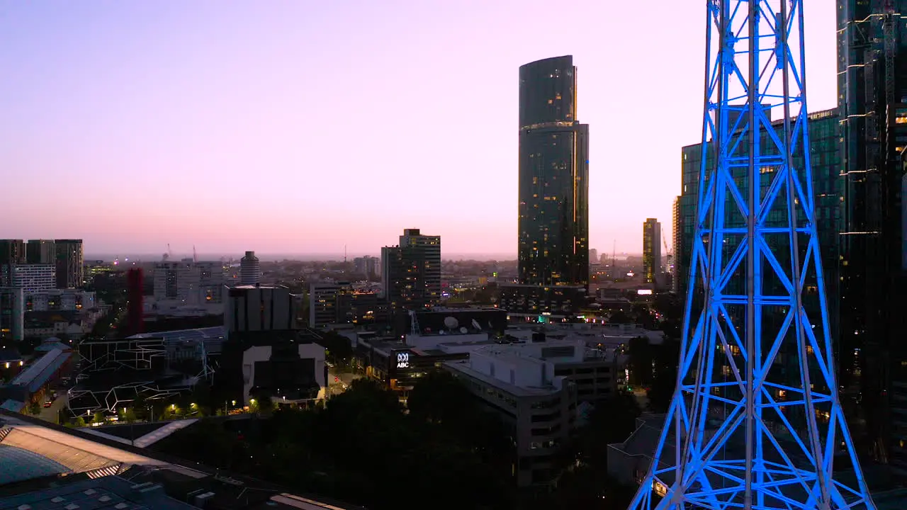 Melbourne Art Spire highlighted with blue neon glowing against gorgeous dusk city skyline