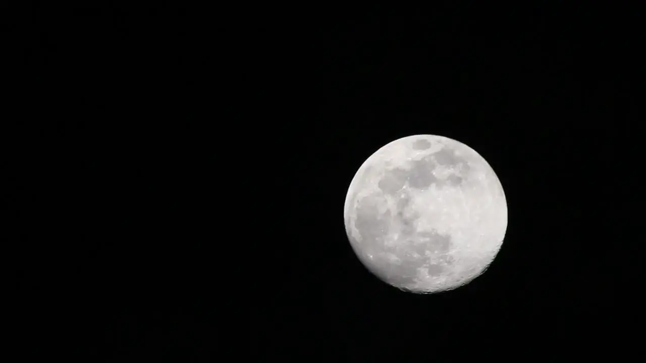 Very faint clouds passing in front of full moon