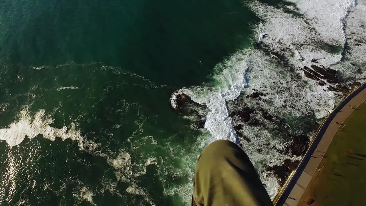 POV of a paraglider flying over the ocean and promenade