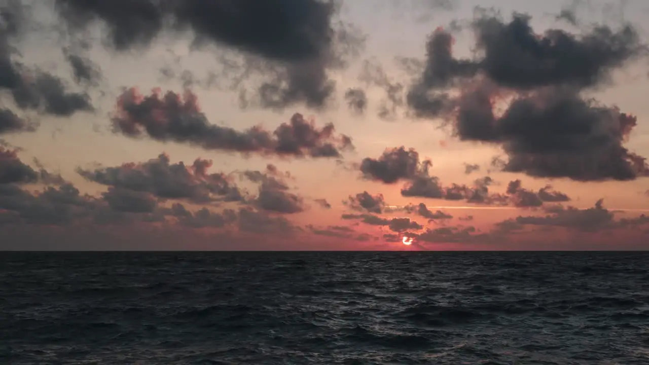 Time lapse of a sunset on the sea level during partly cloudy sky