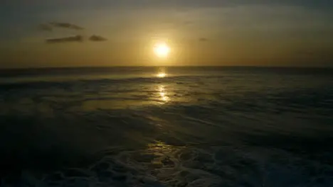 Drone Shot Flying Over Waves Looking at Sunset