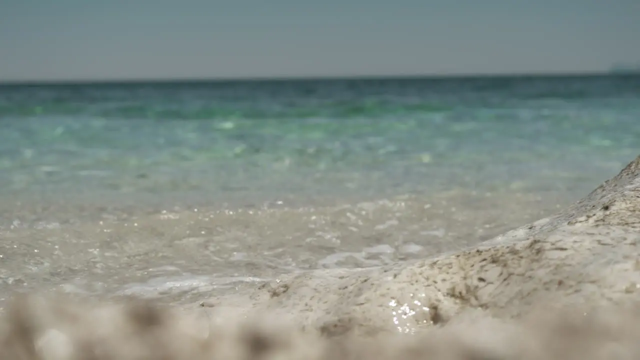 Turquoise blue sea waves splashing at rocky beach in Sicily Italy