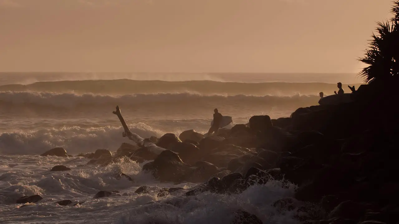 Surfers waiting to enter the water at sunrise at Burleigh Heads on the Gold Coast Australia