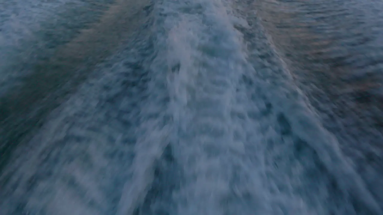 Water spray from wake of a small motor boat at sunset