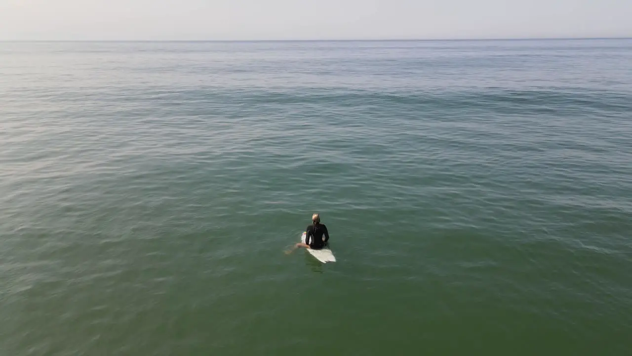 A lone female surfer waiting for a wave