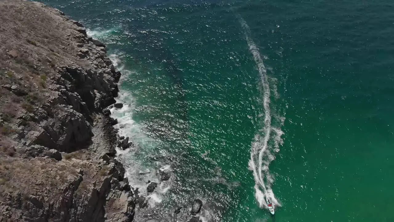 A small boat pulls up near Baja California Mexico and Todos Santos