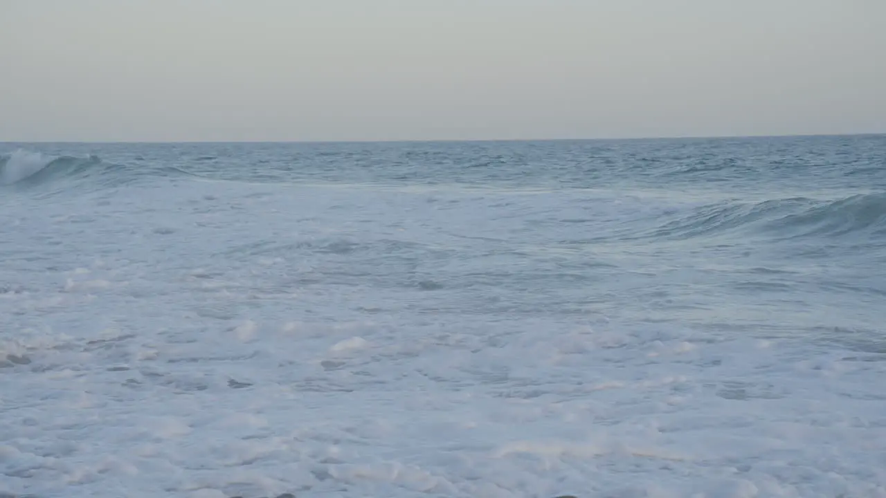 Panning shot from the Pacific Ocean to shore located in Southern California