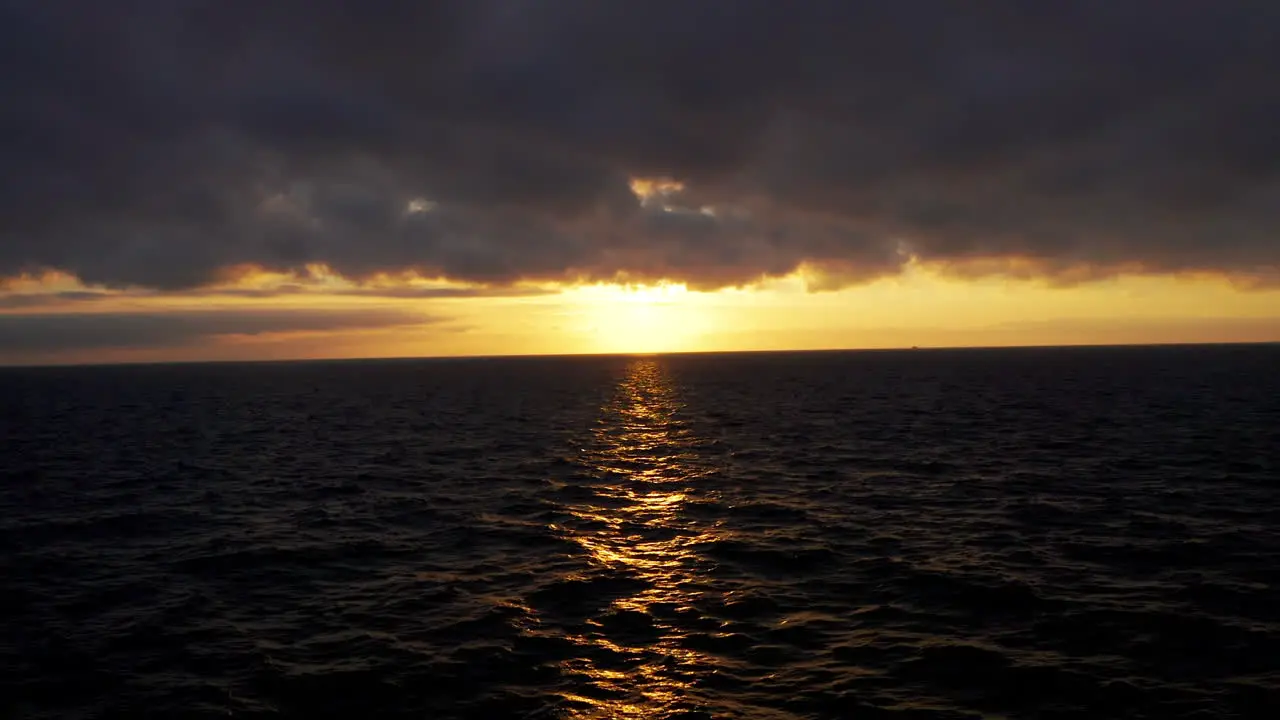 Aerial view flying into the sunset at the end of sunset over the ocean in Laguna Beach California