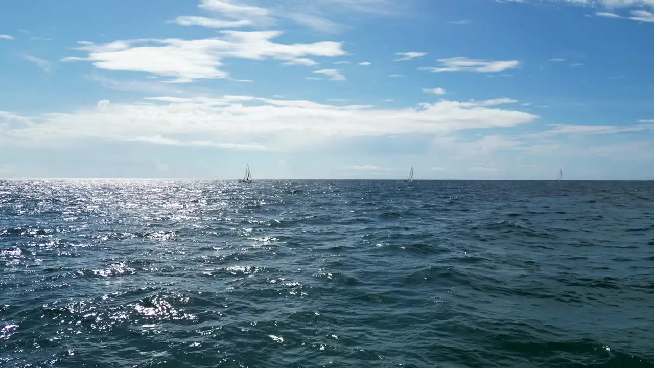 Low drone shot of boats on the ocean and horizon