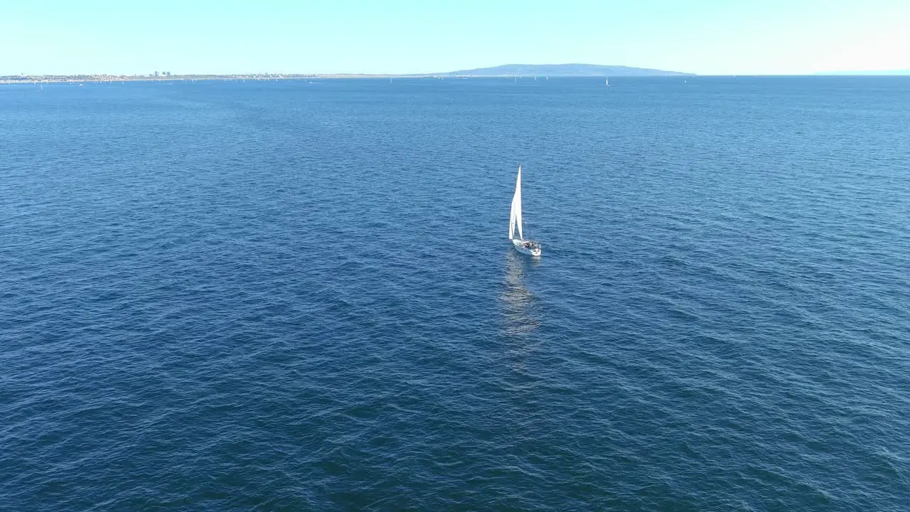 Flying over a sailboat in the Pacific Ocean off the coast of Pacific Palisades California | Flyby Aerial Shot | Sunny Afternoon