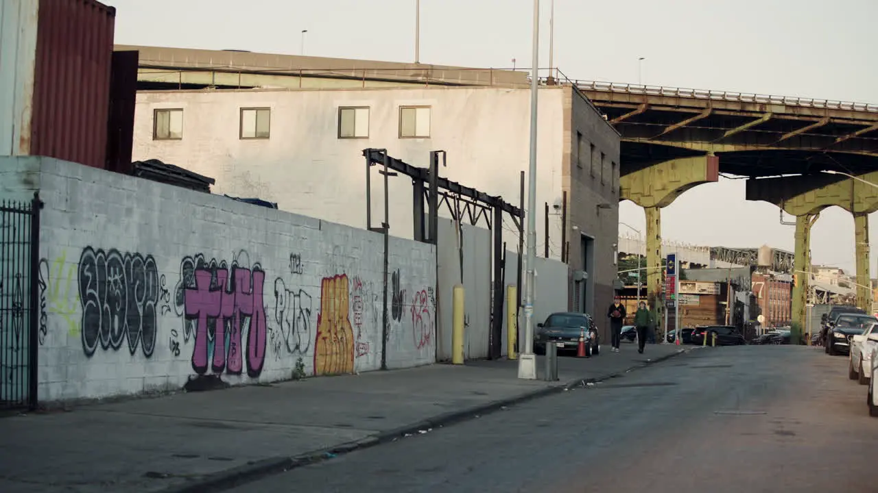 Two Boys Walk Down Empty Street In Redhook Brooklyn NYC