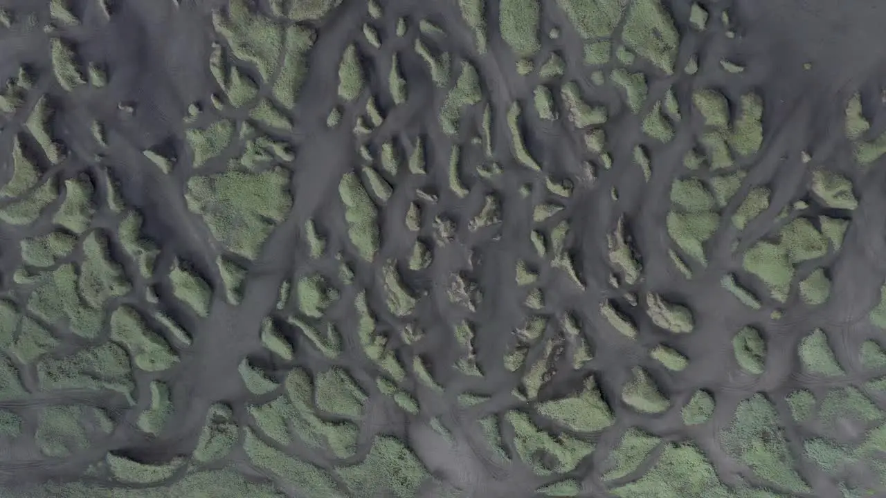 Top down aerial of famous Sandvik beach with grass dunes and black volcanic sand