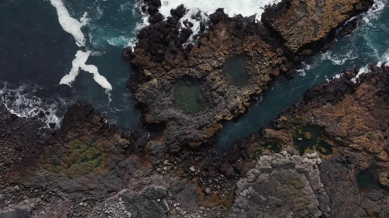 Basalt rock coast in Iceland with tranquil waves hitting shore aerial