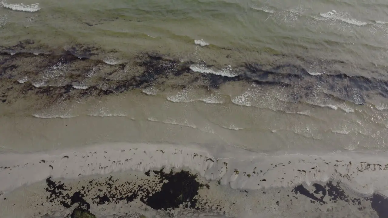 Drone View Of A Rough Beach In Denmark With Waves Tilting Down To Up