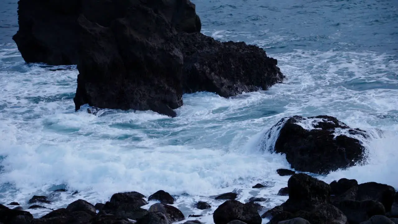 Stormy swell waves crashing on rugged basalt rock shore Iceland