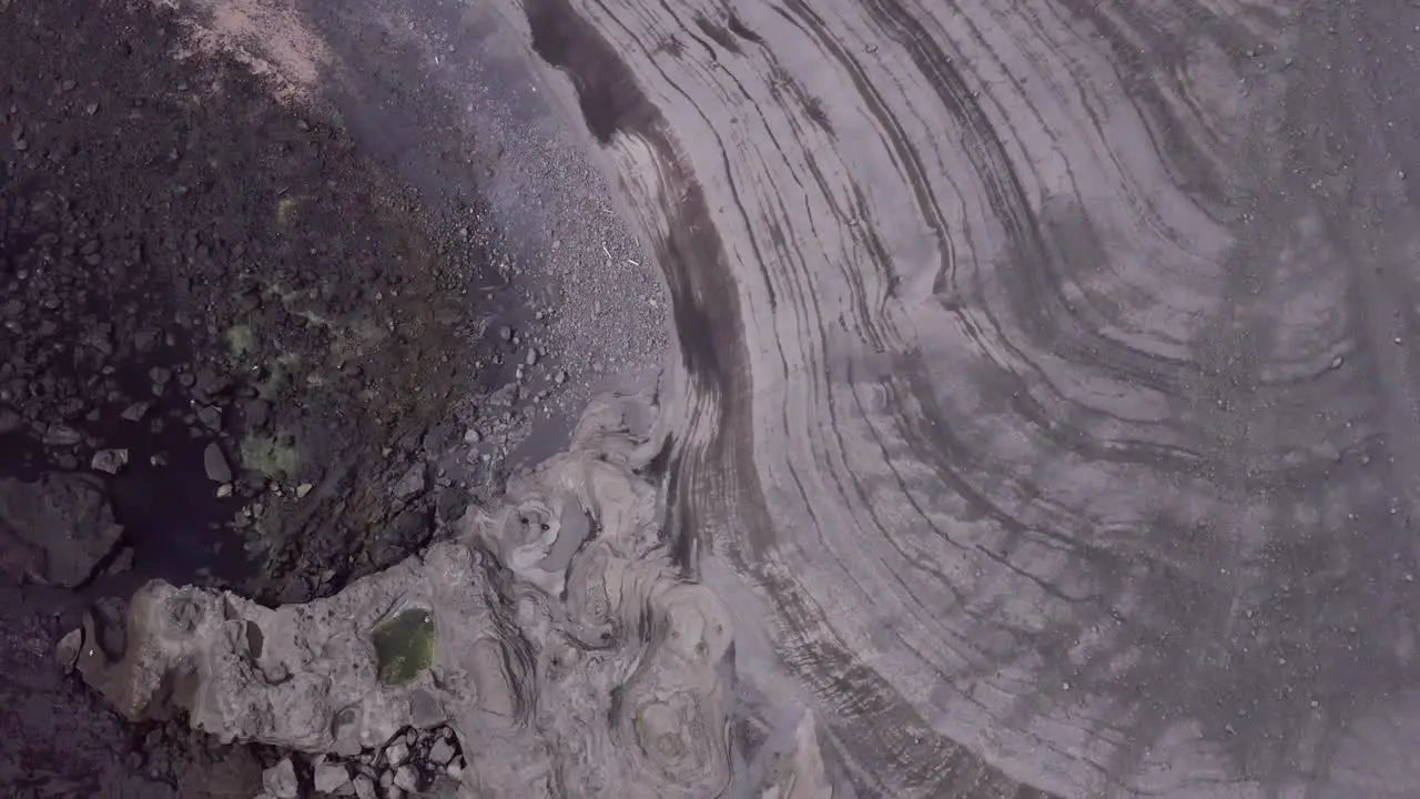 Volcanic lines on coast of Stórhöfði peninsula of remote island Heimaey aerial