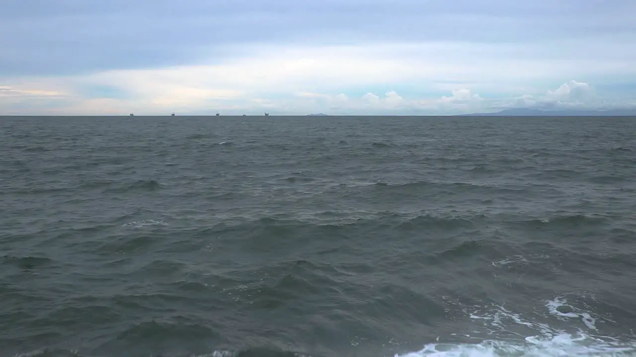 revealing shot of concrete wall only to discover a wide open ocean when the camera becomes high enough