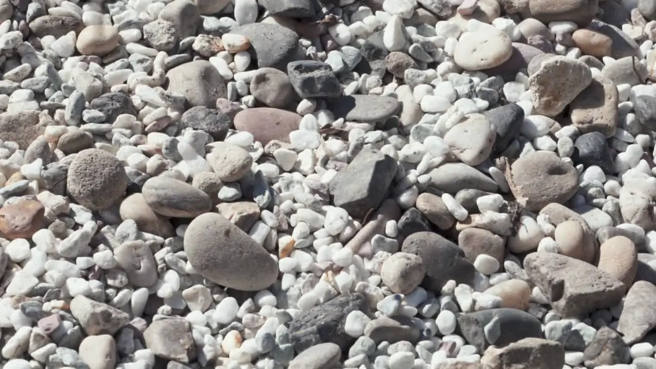 Dropping beautiful stones on other stones static close up view