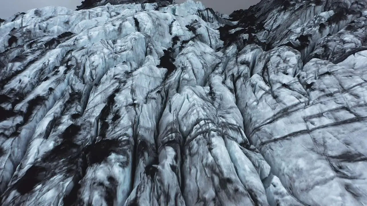 Jagged ice flowing down mountain as Glacier Sólheimajökull aerial